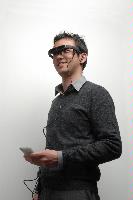 A set of photographs of a pair of glasses containing screens in place of the lenses being modeled by a man.  3 images.