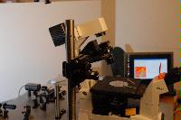 A set of photographs of an unknown experiment involving a microscope, an unknown circuit board and some sensor which is connected to a computer.