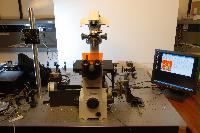 A set of photographs of an unknown experiment involving a microscope, an unknown circuit board and some sensor which is connected to a computer.