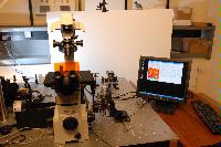 A set of photographs of an unknown experiment involving a microscope, an unknown circuit board and some sensor which is connected to a computer.