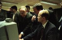 Photographs of Professor Arthur Trew, Professor Richard Kenway, Lord Sutherland and other unknown men looking at a computer screen. There is a Cray T3D supercomputer in the background.