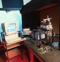 A man setting up some optics equipment.  2 images.