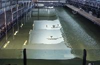 A photograph of some experiments with a device which generates electrical energy from wave kinetic energy.  8 images.