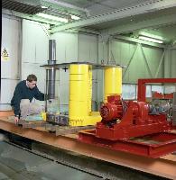Two men set up an experiment in a water tank for what is likely a fluid dynamics experiment.  A laser is used in the water - possibly for particle image velocimetry / PIV.  What looks like an oil platform is set up above the water for some unknown testing.  10 images.