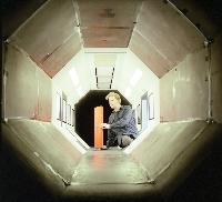 A set of photographs of a fluid dynamics experiment where a rudder / wing is placed into a wind tunnel.  Also shown are the unknown pieces of equipment involved. 6 images.