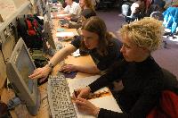 Photographs showing the class of the High Powered Computing MSc students 2005/2006, working in a computer lab suported by EPCC staff, including Dr Fiona J L Reid.