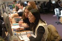 Photographs showing the class of the High Powered Computing MSc students 2005/2006, working in a computer lab suported by EPCC staff, including Dr Fiona J L Reid.